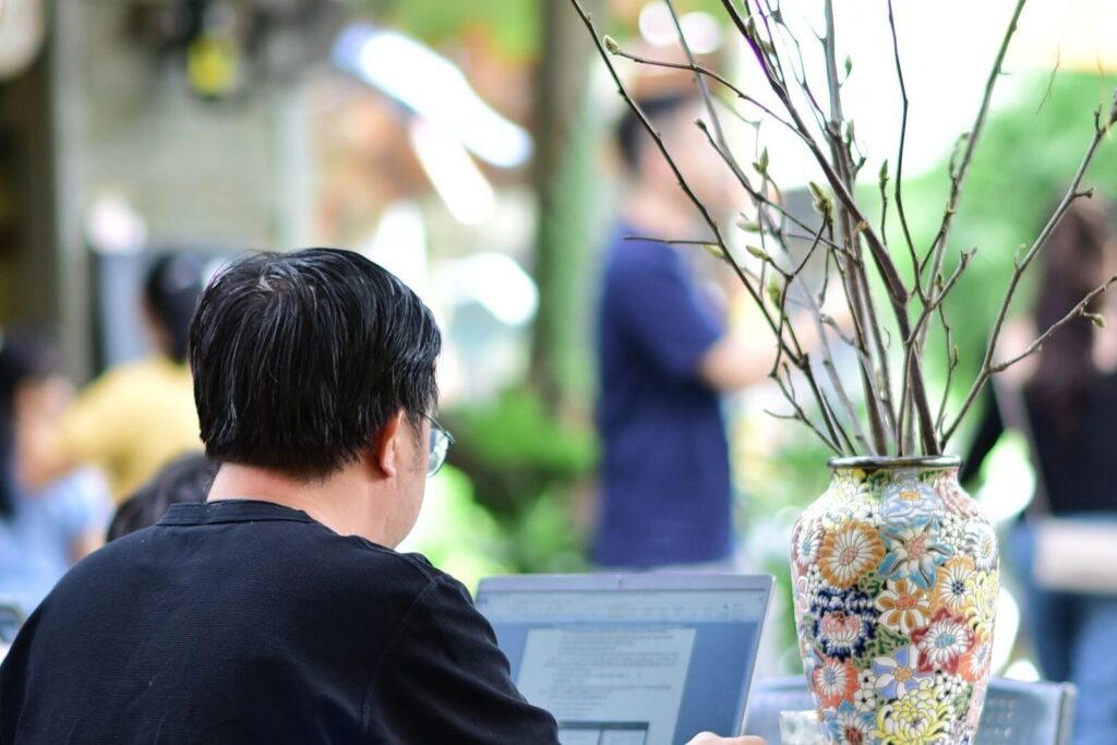 People working on laptops in an outdoor garden cafe, in this Tailscale Ubuntu guide