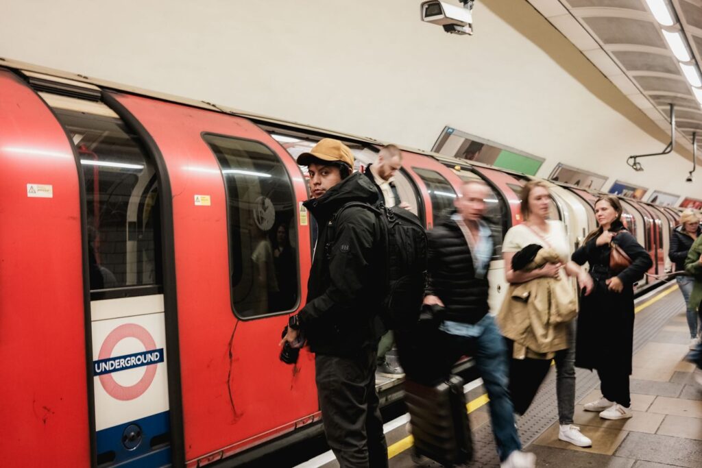 Crowd of people on a London Underground platform beside a red train