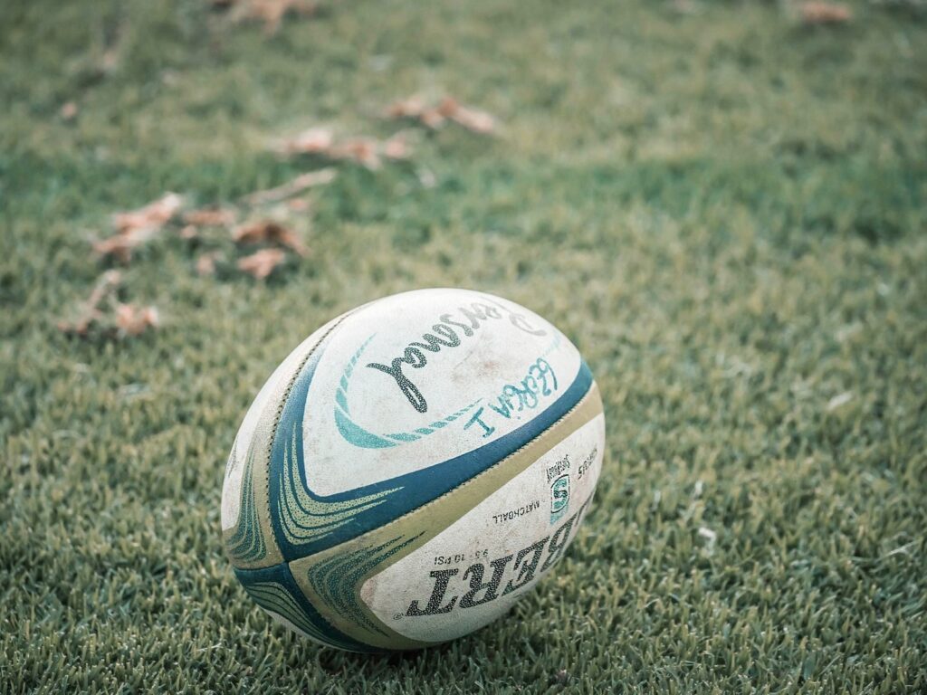 Close-up of a rugby ball resting on grass