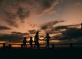 Family walking hand in hand at sunset; a walk after eating can help blood sugar